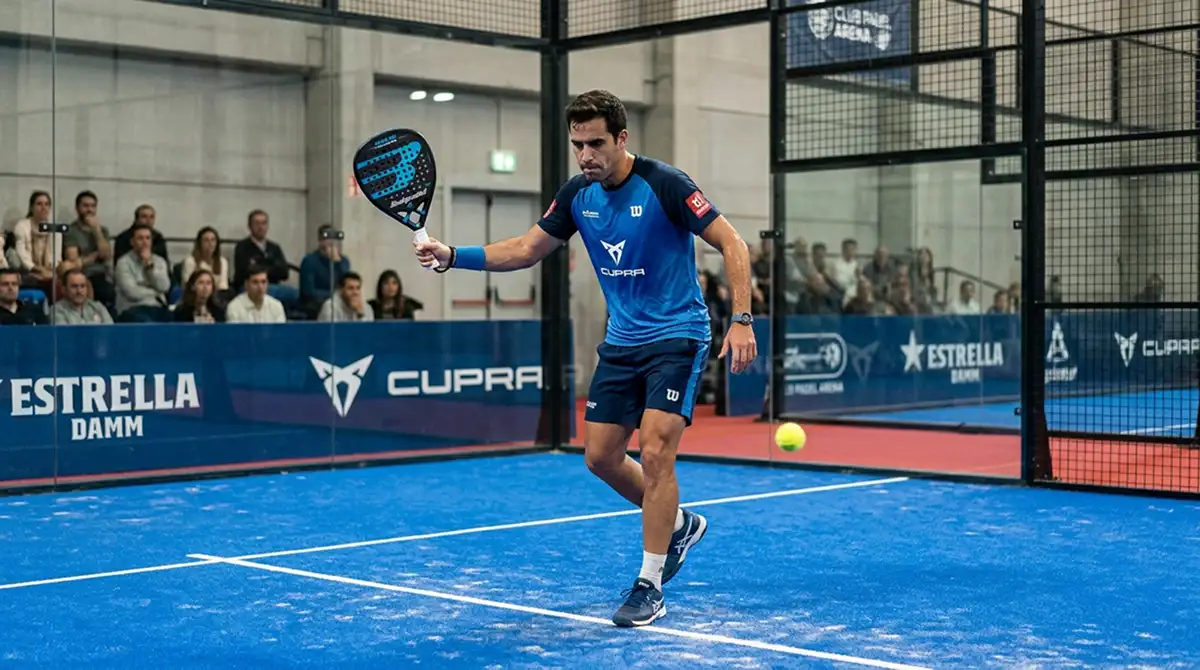 Giocatore di padel che colpisce un secondo servizio mentre la palla esce dalla zona di battuta