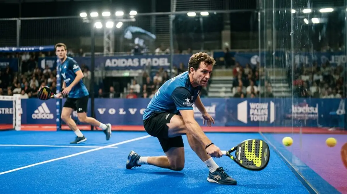Giocatore di padel in difesa estrema vicino alla parete in vetro durante una semifinale Premier Padel